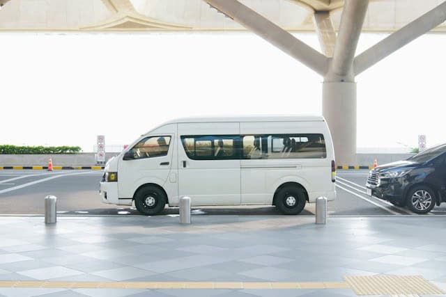 White Minivan Parked at Airport Terminal